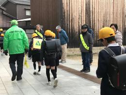 ランドセルを背負った小学生が登校しながらあいさつをしている写真