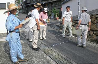 防災マップを片手に現状を確認している6人の男性たちの写真