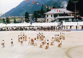 校庭で太鼓を演奏している小学生たちの写真