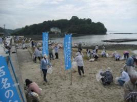 海岸の砂浜を清掃している参加者の皆さんの写真