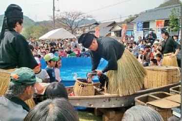 鵜飼が鵜を操っている様子を見ている人々の様子の写真
