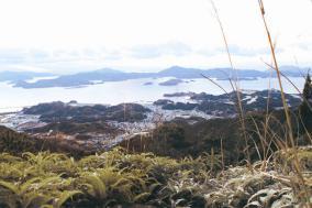 山から見下ろした街並みと海の写真