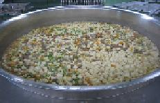 巨大な窯の中で煮込まれていく野菜の写真