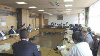 ロの字に配置されたテーブルを挟んで消防署担当者から講評を受ける議員達の写真