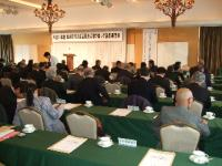 緑のテーブルが横列に並べられた会場で議員達が座りならぶ姿を後ろから撮影した写真