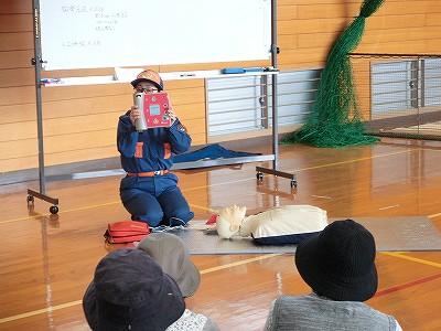 消防士がAEDを持ち説明している写真