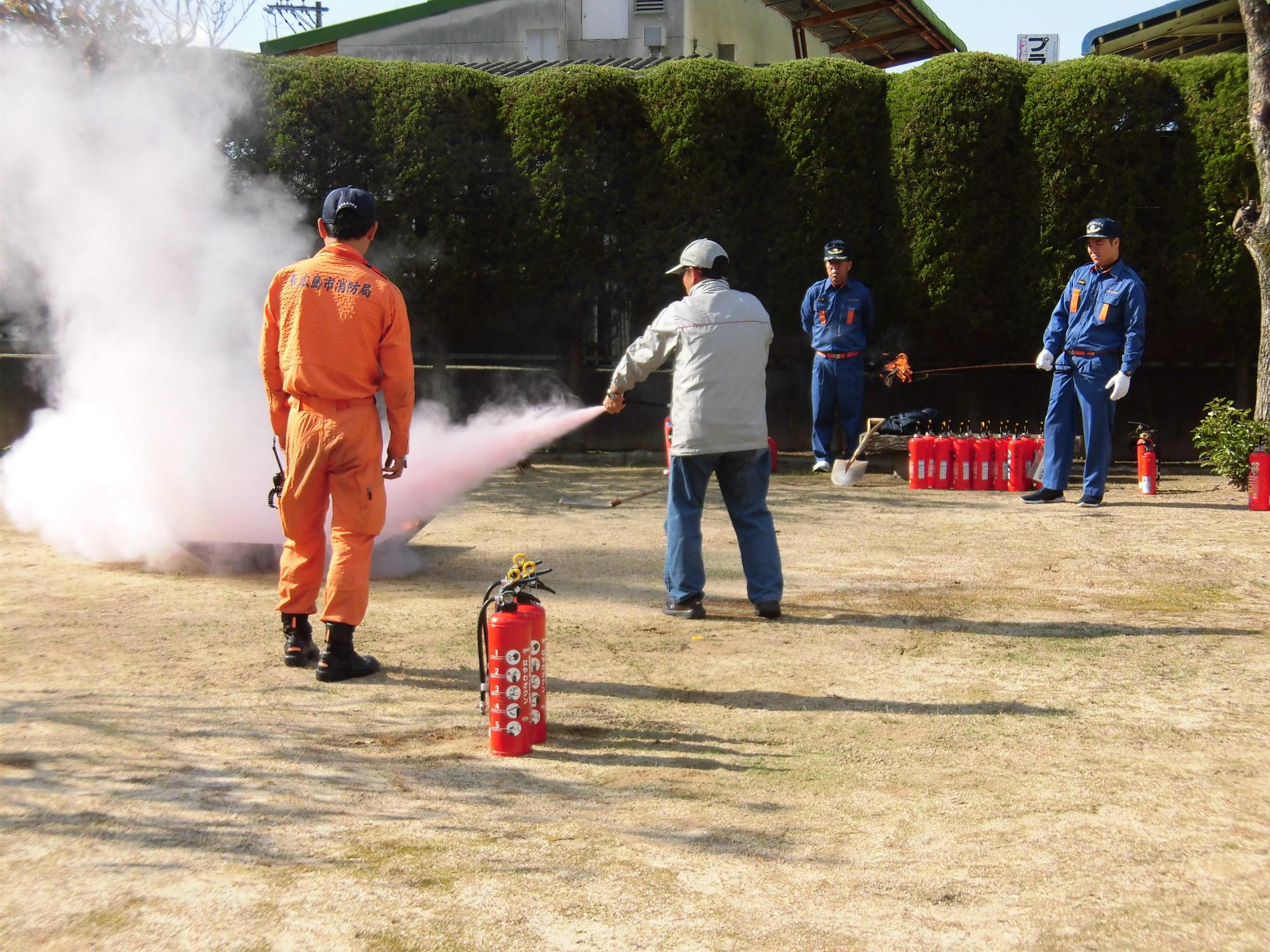 消火器を使って火を消している訓練の写真