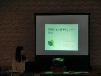 吉和おさんぽギャラリーと映されているスクリーンとその説明をしている女性スタッフの写真