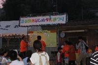 オレンジ色のスタッフジャンパーを着ている3人のスタッフがビンゴの番号を照合している様子の写真