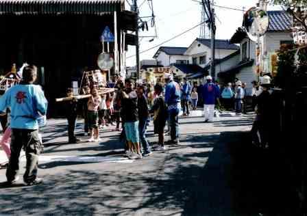 恵美須祭にて路上に担がれた神輿が通る様子を撮影している写真
