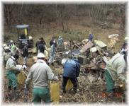 不法投棄されたゴミを撤去している関係者たちの写真