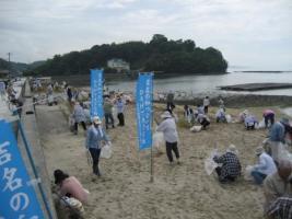 海岸の砂浜を清掃している参加者の皆さんの写真