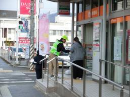 建物の入口付近で特殊詐欺被害防止啓発活動の案内をしている写真