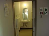 ドアの奥に照明が点灯しているオストメイトトイレの入口の写真