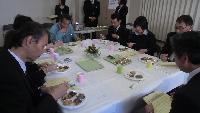 白いテーブルに並べられたコンテストの料理を審査員が試食している写真