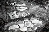 平面の多数の大きな石が散りばめられているモノクロの田万里鏡田古墳群の写真
