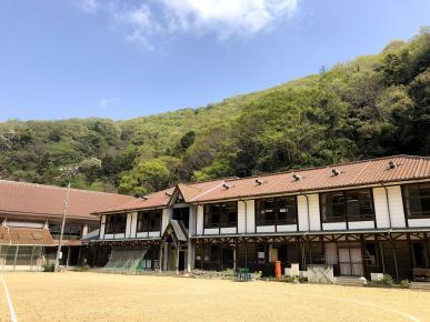 山の麓にある茶色い屋根の学校の写真